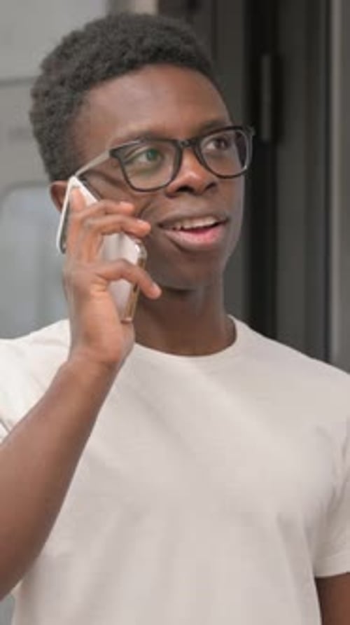 Young Man in Glasses Talking on Mobile Phone