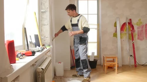 Man Painting Window Trim During Home Renovation