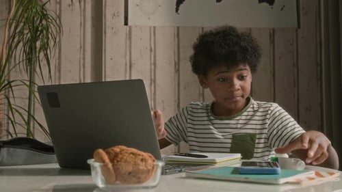 Child Using Laptop At Desk Indoors