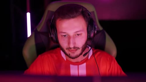 Man Gaming with Headphones in Dark Room