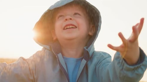 Smiling Boy Enjoys Rain Shower Outdoors