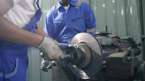 Men Working on Car Part in a Garage