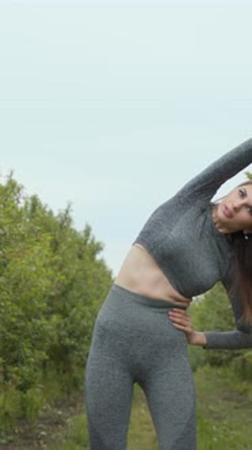 Woman Stretching Outdoors in Gray Athletic Set