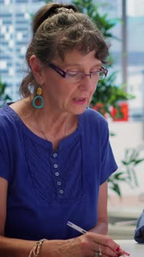 Woman Taking Notes in Office Meeting