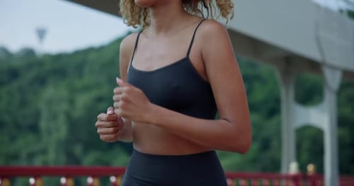 Young African American Woman Runner Jogging on City Bridge Outdoors