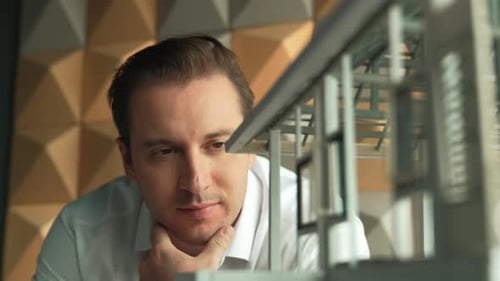 Gros plan du visage d'un ingénieur professionnel regardant un modèle de maison. Manipulateur.