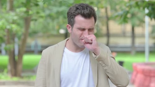 Outdoor Portrait of Casual Young Man Coughing