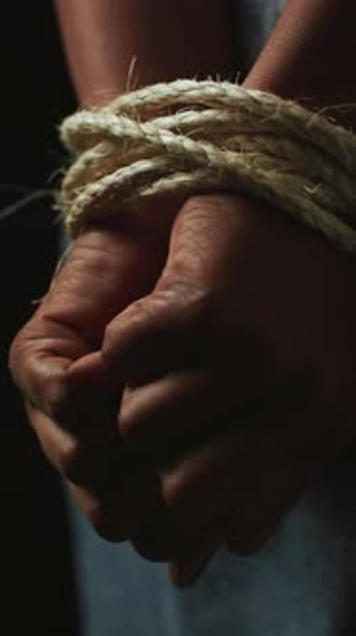 Kidnapped, hands and prisoner with rope in studio, abduction crisis and capture hostage for bondage