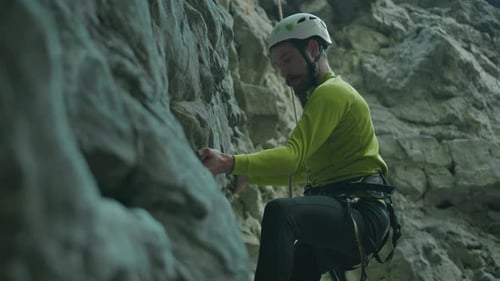 Extreme Guy Climbing Up Mountain Bearded Active Slim Sportsman Gridding Holds and Carefully Moving