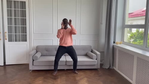 Man Dancing Indoors in a Well-Lit Room
