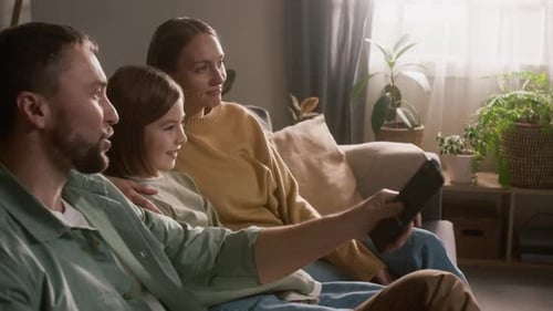 Family Watching TV Together in Cozy Home