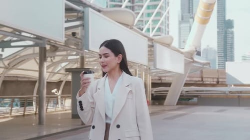 Young beautiful business woman holding coffee cup ready to work in modern city