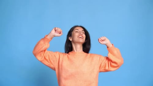 Woman Dancing Joyfully on a Blue Background