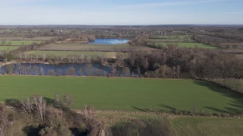 Drone aerial view flying over green fields and lakes