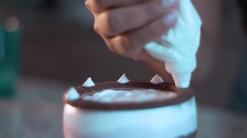 Decorating a parfait with mint leafs and berries