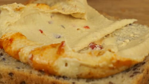Hummus Spreading on Multi-Grain Bread Slice