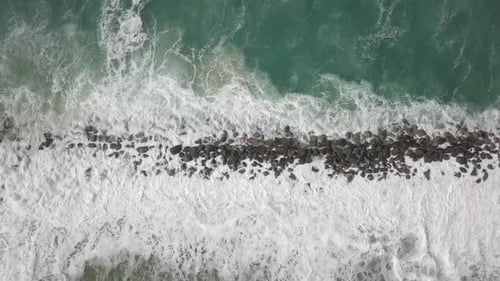 Ocean Waves Crashing on Rocky Shoreline Aerial View
