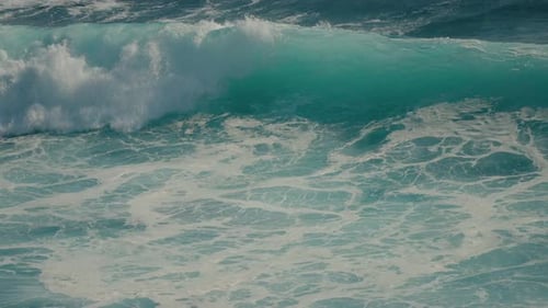 Large turquoise ocean wave crashing in super slow motion