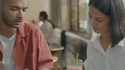 Man Discussing Business Plan with Female Colleague at the Cafe