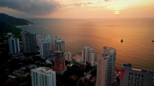 Aerial drone view of Santa Marta, Colombia.
Flying over Colombian coastline city at sunset. View of
