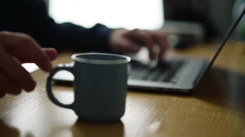 An einem ruhigen Nachmittag an einem Holzschreibtisch mit einer Kaffeetasse in der Nähe arbeiten