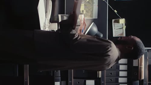 Detective Investigates Evidence in Dark Office