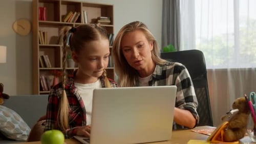 Mother and Daughter Using Laptop Computer at Home