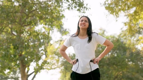 Woman Exercising with Skipping Rope Outdoors