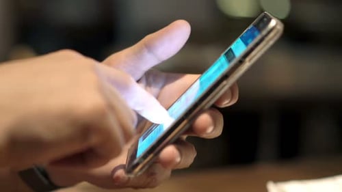 Man Using Smartphone Sitting by Table in Cafe 30s