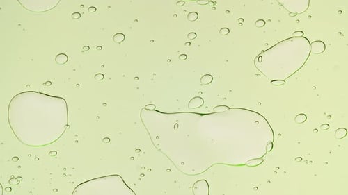 Transparent Green Cosmetic Gel Fluid With Molecule Bubbles and Oil on White Background