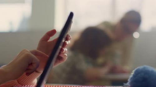 Child Uses Tablet with Adult Helping in Background