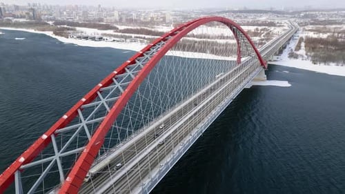 Cars Drive Across the City Bridge Over the River on a Winter Morning