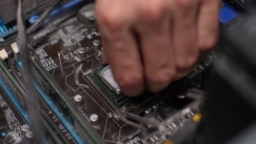 Hand Removing Computer Chip From Motherboard Close Up