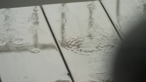 Raindrops Falling on Wet Surface in Close-Up