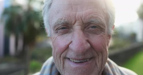 Close Up of Senior Man Smiling on Camera with City in The