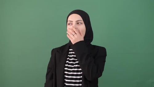 Young Woman Yawning Against Green Background