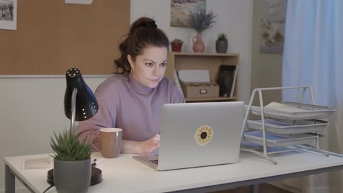 Stressed Woman at Home Office Desk at Night, Laptop and Starts Typing on Computer. Bad News Reaction