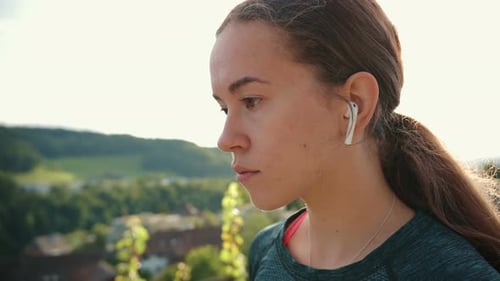 Young Woman Listening to Music Outdoors