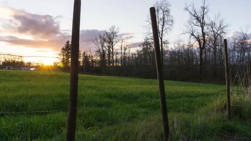 Sunset TimeLapse at the Barb Wire Fence in Front of a Green Grass Field Vancouver BC Canada