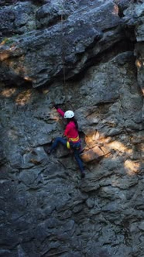 Young Brunette Caucasian Woman in Sports Climbing Up Mountain Reaching Top Wearing Helmet Safety