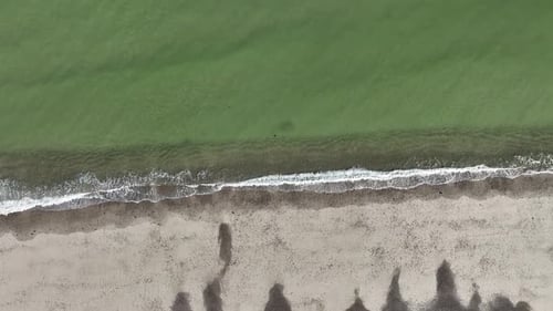 Sandy neck beach in cape cod with gentle waves meeting the shoreline, aerial view