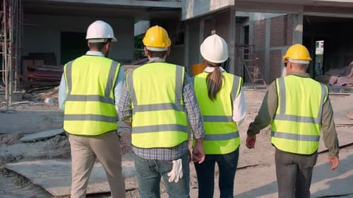 Construction Workers Walking Through Urban Building Site