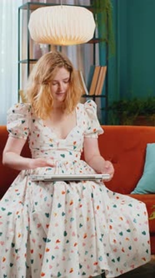 Woman Sitting on Couch Using Laptop Computer Indoors