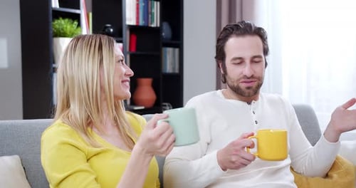 Happy Couple Talking on Couch at Home