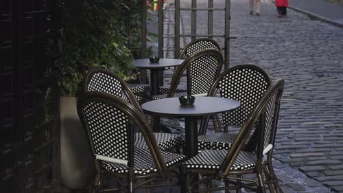 French Style Chairs Sitting Outside A Restaurant Empty On A Cobbled Road