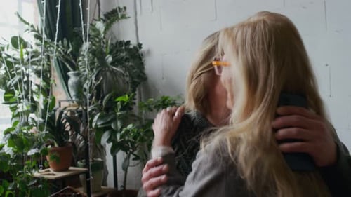 Group of Happy Friends Hugging and Kissing while Meeting in Green Cafe