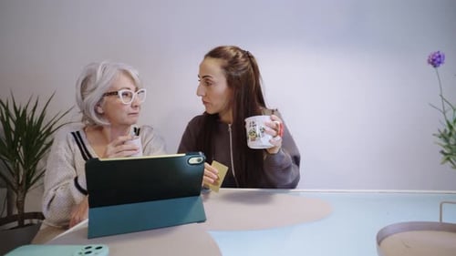 Mutter und Tochter teilen sich einen Moment mit Kaffee und Tablet