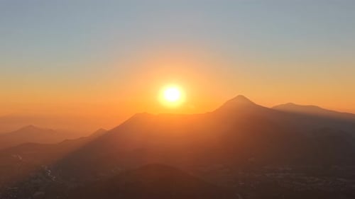 Vídeo aéreo de una puesta de sol entre las montañas de la ciudad de Santiago, Chile