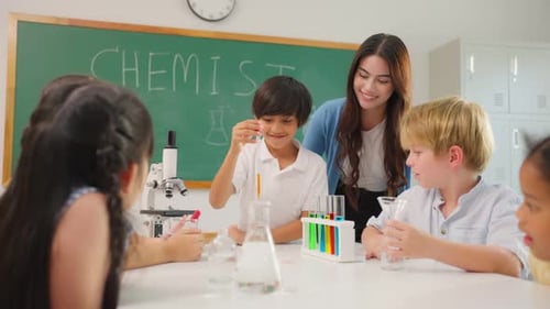 Adorable student learn with teacher in classroom at elementary school.