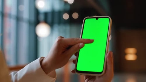 Hands Browsing Message Greenscreen Mobile Phone in Business Center Closeup